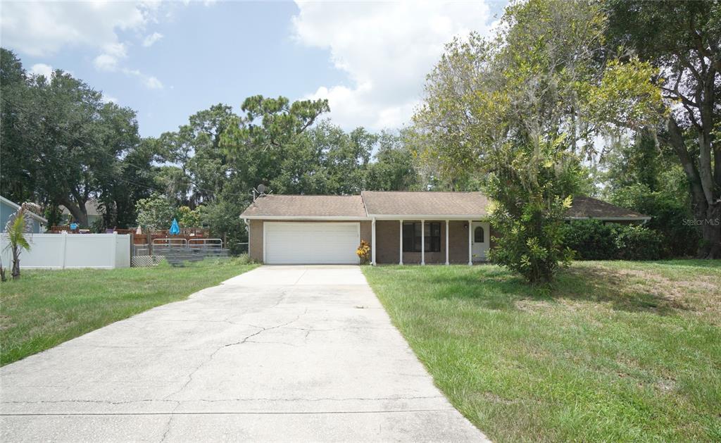 A single-story brick house with a two-car garage and a concrete driveway — 6005 CHRISTY LANE, RIVERVIEW, FL
