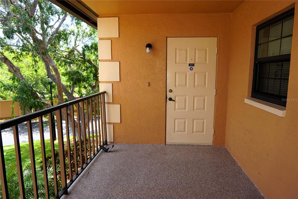 An exterior view of a two-story apartment building with a highlighted upper-level unit — 12900 VONN ROAD UNIT B201, LARGO, FL