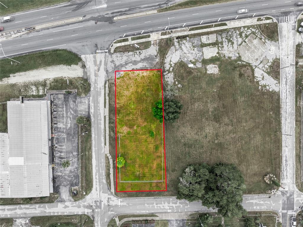 An aerial view shows a rectangular vacant lot outlined in red near a paved road — 409 NW 8TH STREET, OCALA, FL
