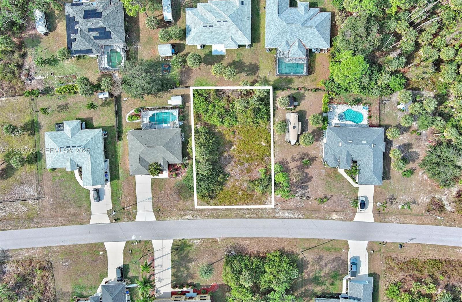 An aerial view shows a vacant rectangular residential lot situated between two houses with pools — 0 SADNET LN, North Port FL 34286, NORTH PORT, FL