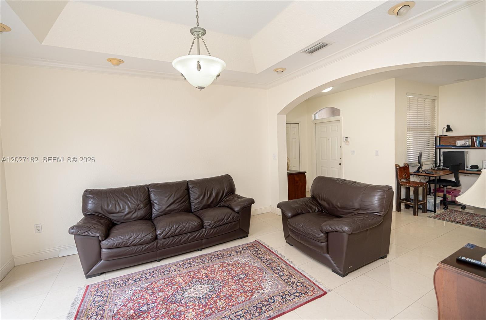 A living room features a leather sofa and armchair on a patterned area rug — 14372 NW 83rd Ave, Miami Lakes FL 33016, MIAMI LAKES, FL