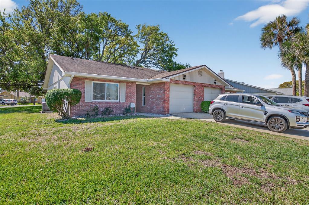 A single-story brick house with a two-car garage and a silver SUV parked outside — 1400 PORTOBELLO DRIVE, PORT ORANGE, FL