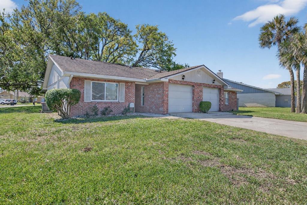 A single-story brick house with a two-car garage and a large front lawn — 1400 PORTOBELLO DRIVE, PORT ORANGE, FL