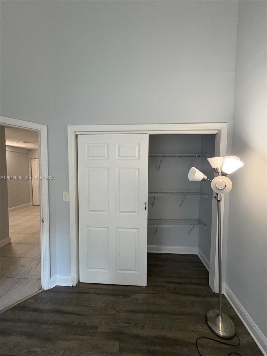 A room features gray walls, dark wood-look flooring, a closet with wire shelving, and a lamp — 2309 NW 55th Ave, Lauderhill FL 33313, LAUDERHILL, FL
