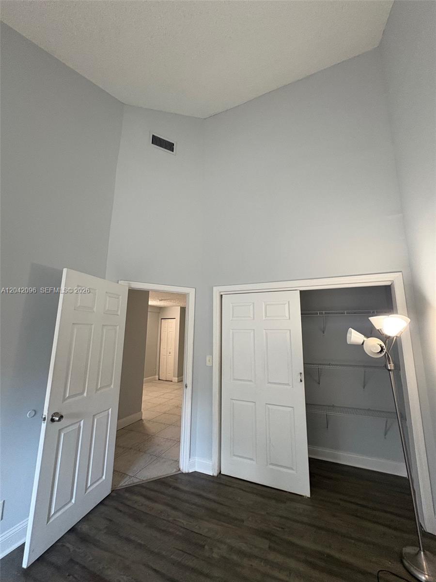 A room with high ceilings, light blue walls, dark flooring, and two open doorways — 2309 NW 55th Ave, Lauderhill FL 33313, LAUDERHILL, FL
