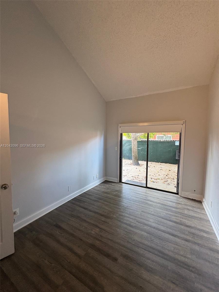 A room with light gray walls, wood-look flooring, and a sliding glass door to a patio — 2309 NW 55th Ave, Lauderhill FL 33313, LAUDERHILL, FL
