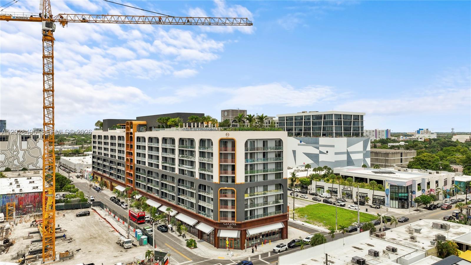 An aerial view shows a modern multi-story apartment building with a construction crane nearby — 2700 NW 2 Ave # 711, Miami FL 33127, MIAMI, FL