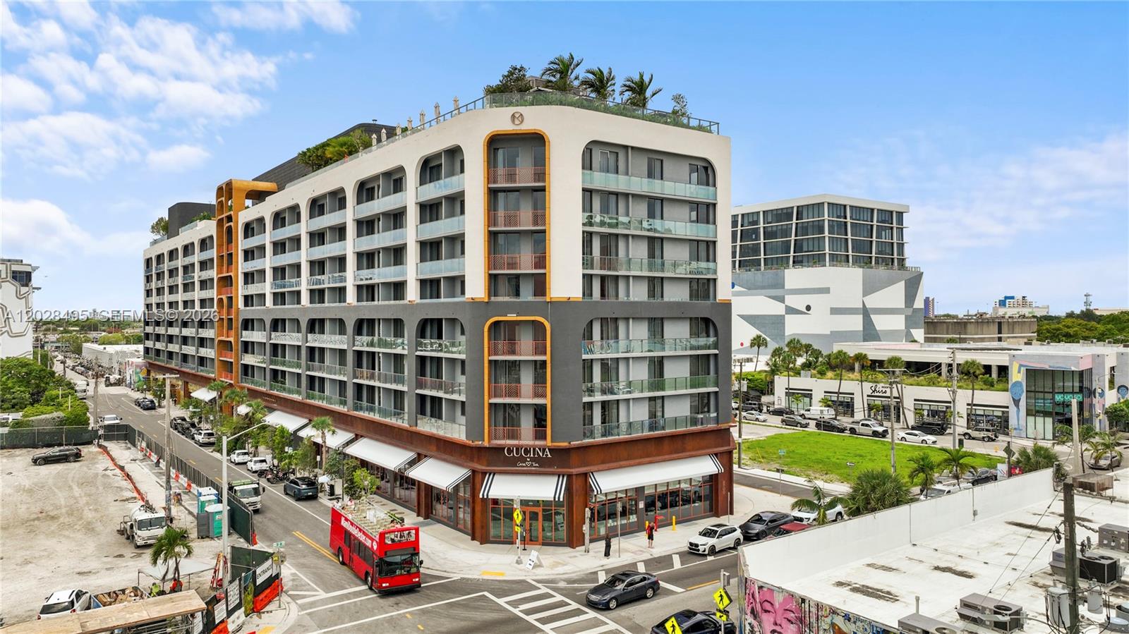 An exterior view of a modern multi-story apartment building with a ground-floor restaurant — 2700 NW 2 Ave # 711, Miami FL 33127, MIAMI, FL