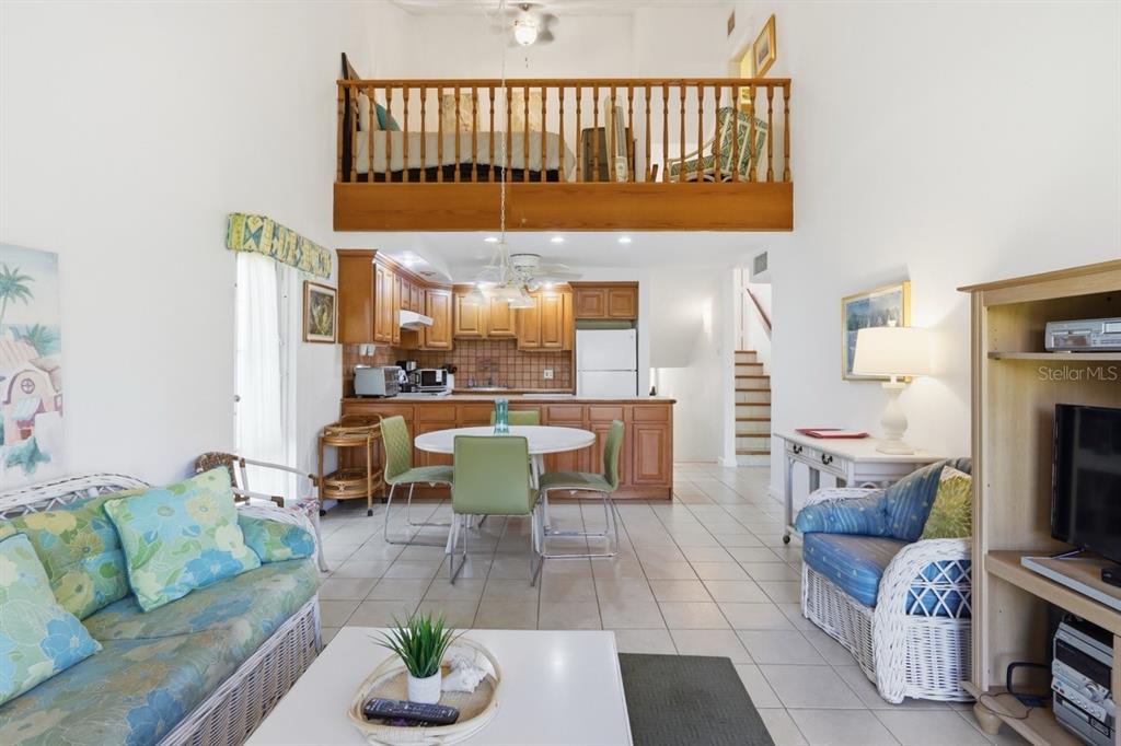 A living room and kitchen area with a loft bedroom overlooking the main floor — 1 BEACH VILLAGE DRIVE UNIT 92, HUMACAO, PR