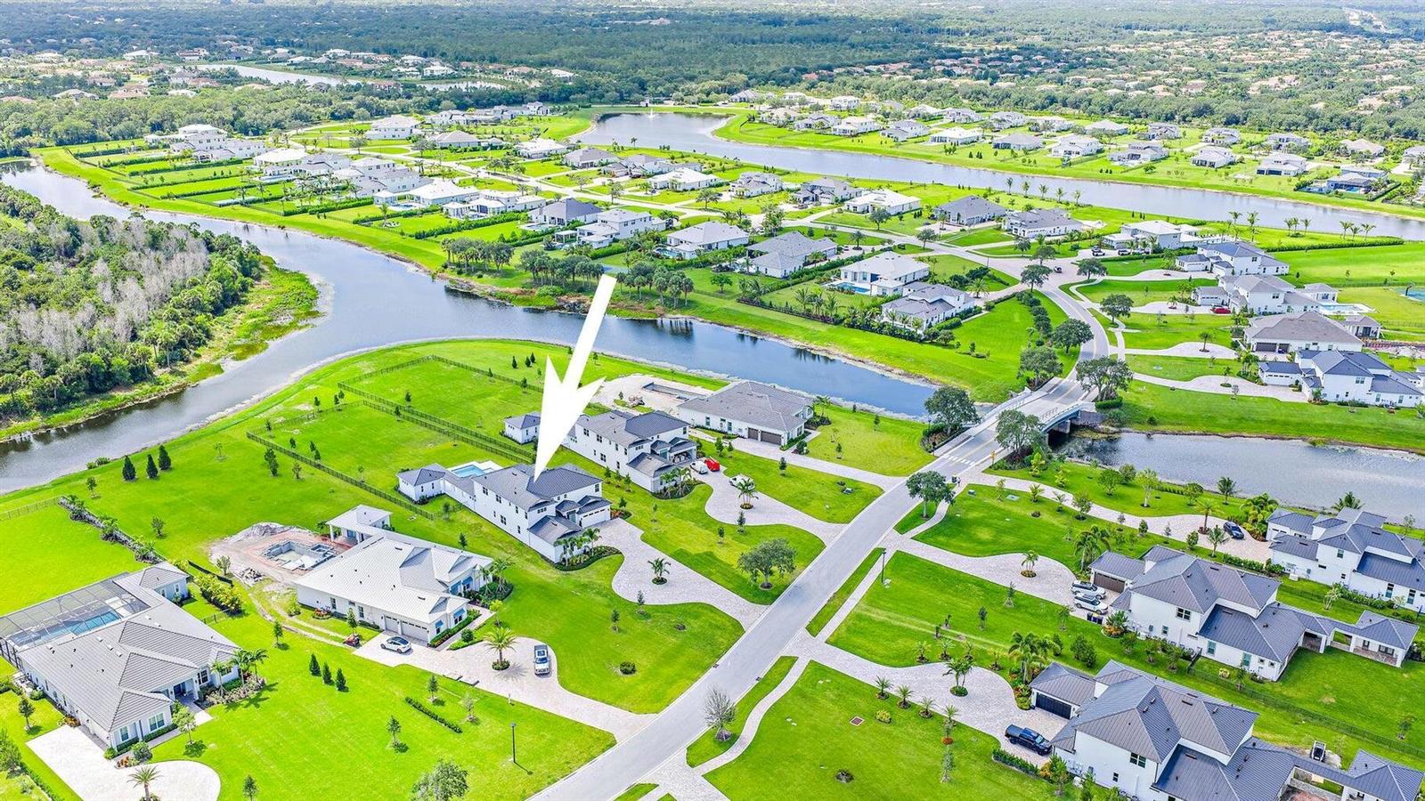 An aerial view shows a modern house with a pool in a suburban neighborhood — 20037 SE Bridgewater Drive, Jupiter FL 33458, JUPITER, FL