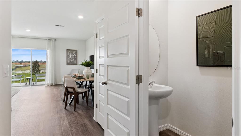 A view from a doorway into a dining area and a small powder room — 4296 BUTTERSCOTCH CIRCLE, LAKELAND, FL