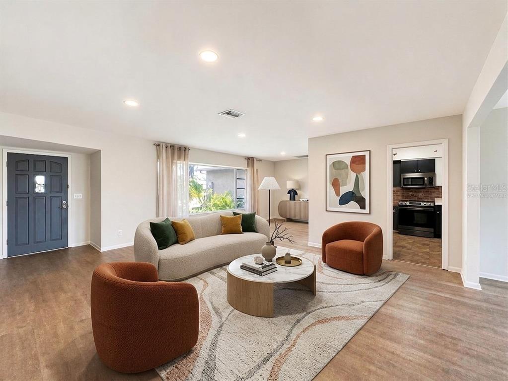 A living room features a curved sofa, two orange armchairs, and a circular coffee table — 356 PEPPERTREE ROAD, VENICE, FL