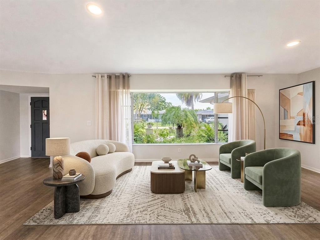 A living room features a curved sofa, two green armchairs, and a large picture window — 356 PEPPERTREE ROAD, VENICE, FL