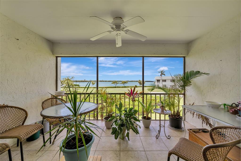 A screened-in patio with tile flooring, a ceiling fan, and a view of the water — 4835 INDEPENDENCE DRIVE, BRADENTON, FL