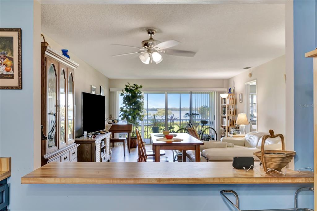 A view from a kitchen counter looking into a living and dining area with water views — 4835 INDEPENDENCE DRIVE, BRADENTON, FL