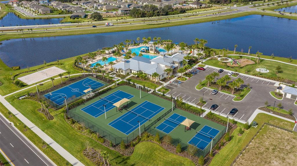 An aerial view shows a community clubhouse with a pool, tennis courts, and parking lot — 5854 SUNLIT BEND WAY, APOLLO BEACH, FL