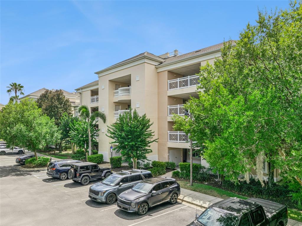 A multi-story apartment building with balconies and a parking lot in the foreground — 1356 CENTRE COURT RIDGE DRIVE UNIT 303, KISSIMMEE, FL