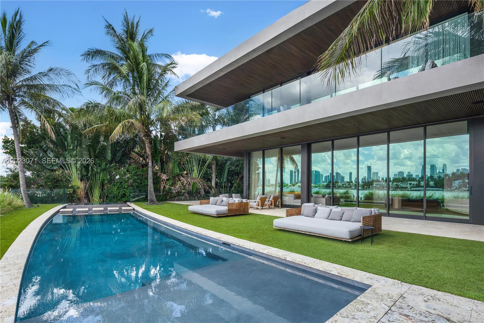 A modern two-story house features a swimming pool and outdoor lounge area with palm trees — 28 W Dilido Dr, Miami Beach FL 33139, MIAMI BEACH, FL