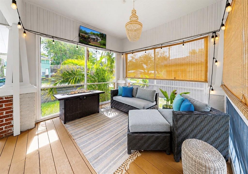 A front porch with brick pillars, wooden decking, and gray concrete steps leads to a house — 6702 N ELIZABETH STREET, TAMPA, FL