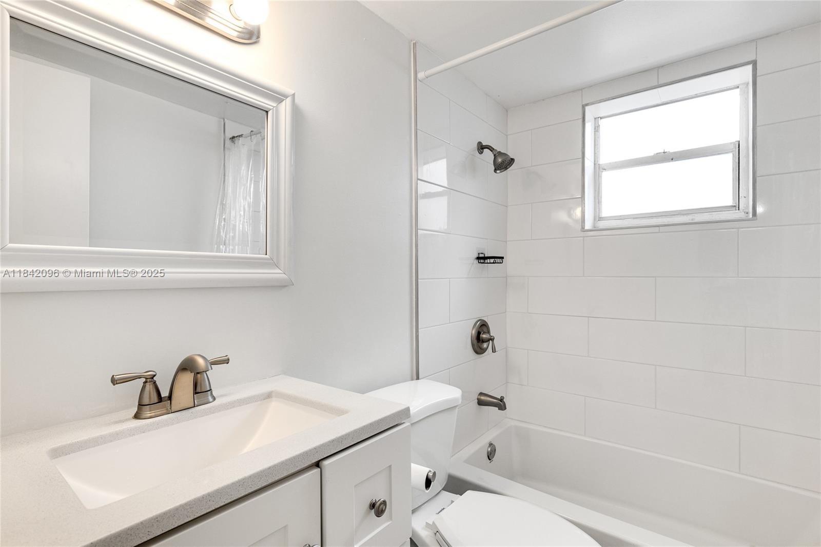 A bathroom features a white vanity, a mirror, a toilet, and a tiled shower-tub combination — 2465 SW 18th Avenue # 3208, Miami FL 33145, MIAMI, FL