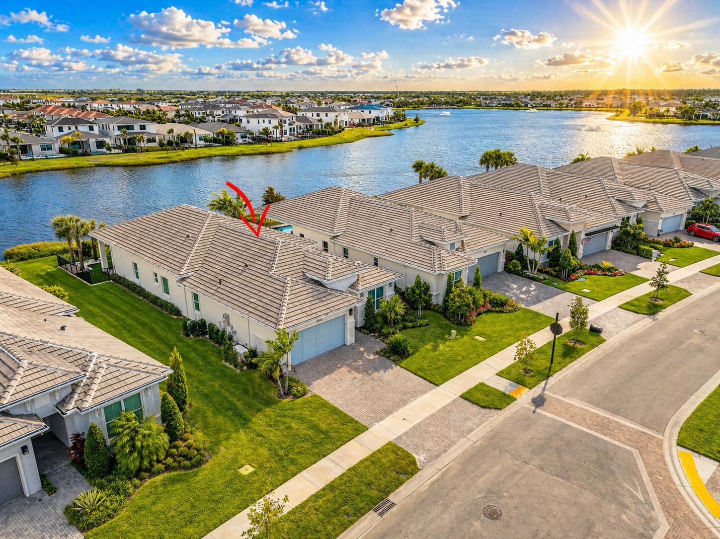 A fenced backyard with artificial turf and a palm tree overlooks a lake at sunset — 10033 Regency Way, Palm Beach Gardens FL 33412, PALM BEACH GARDENS, FL
