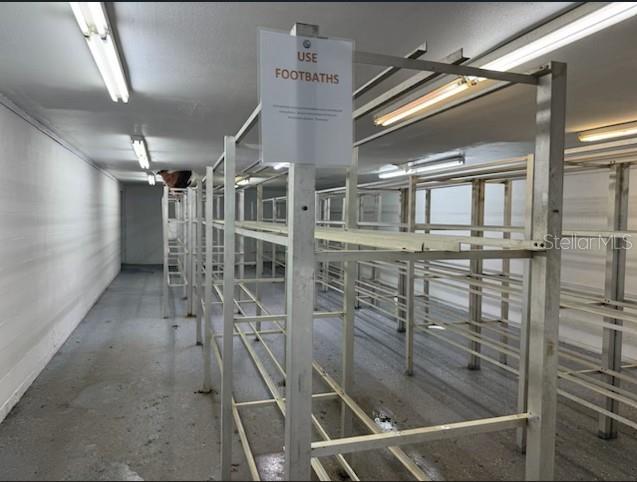 A storage room features metal shelving units and a sign instructing users to use footbaths — 2525 N BETHLEHEM ROAD UNIT B, PLANT CITY, FL