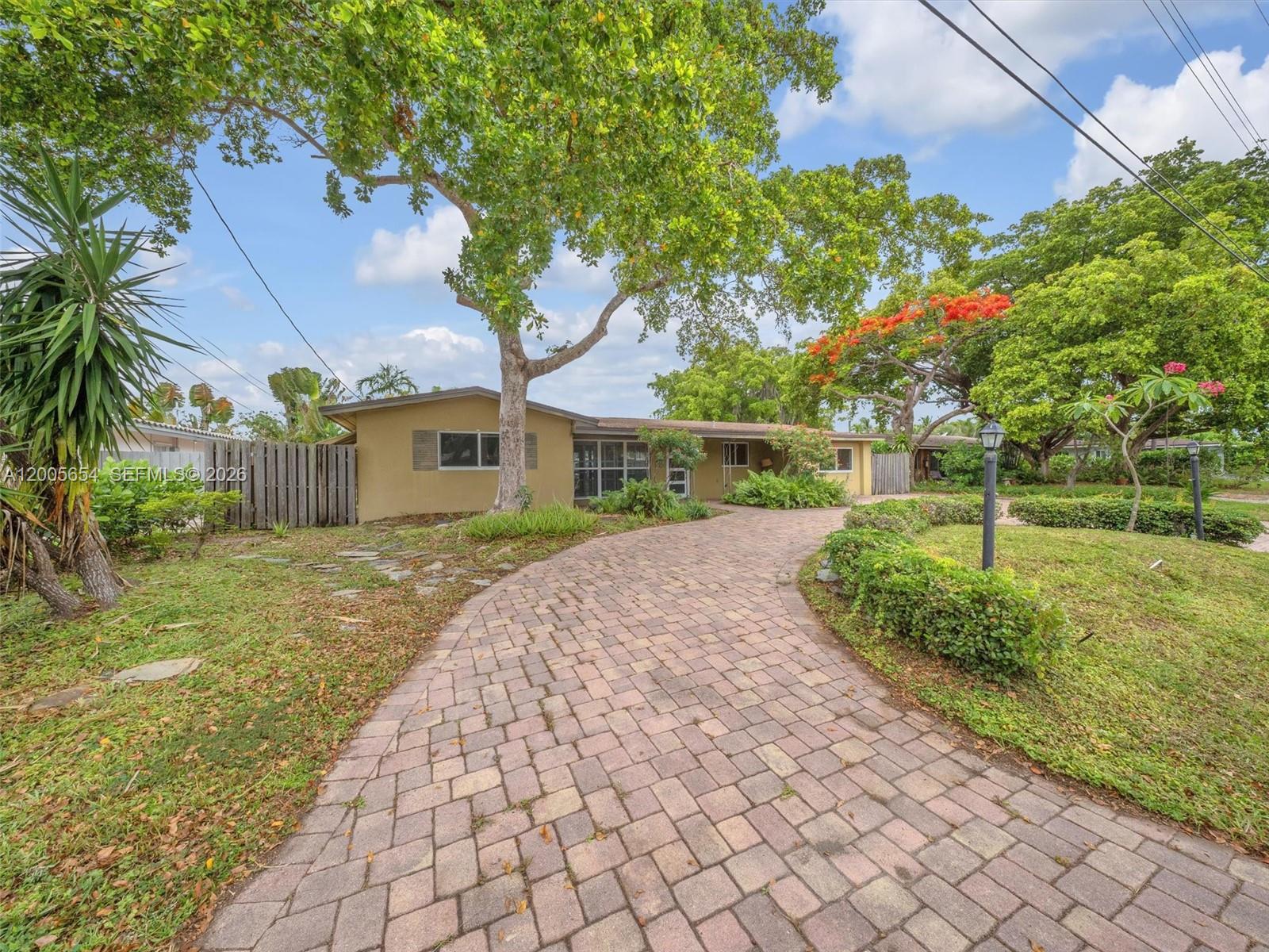 A kitchen with a granite breakfast bar overlooks a dining area with a pool view — 4401 NE 15th Ter, Oakland Park FL 33334, OAKLAND PARK, FL