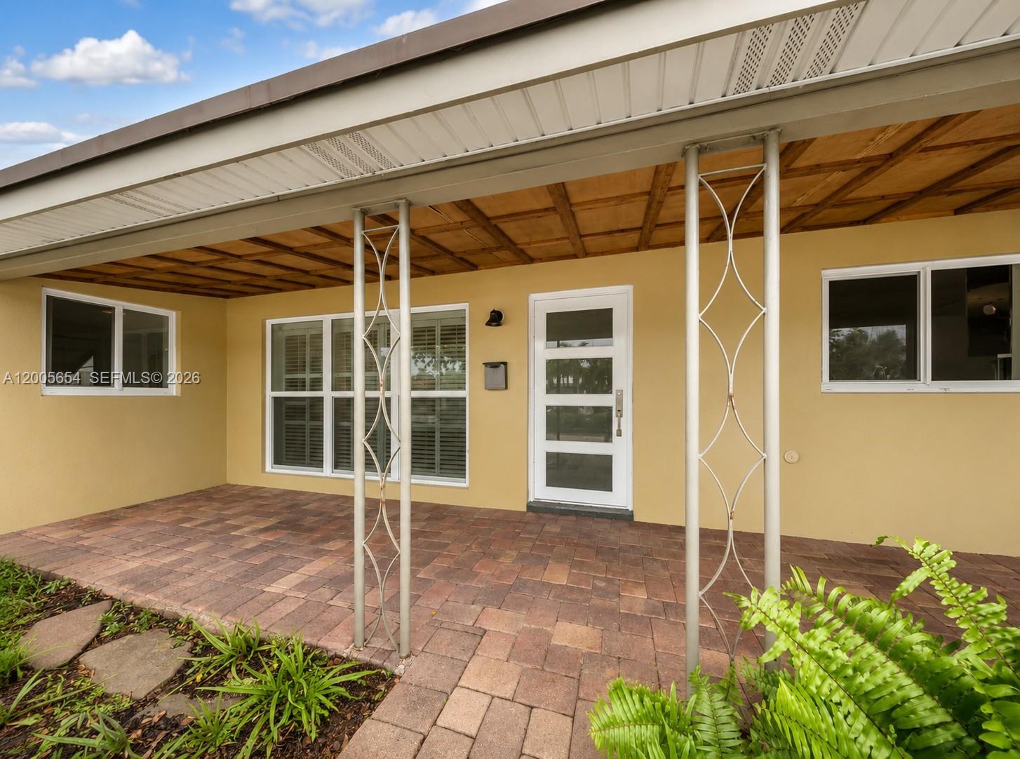 A kitchen and dining area feature wood cabinets, granite countertops, and light wood flooring — 4401 NE 15th Ter, Oakland Park FL 33334, OAKLAND PARK, FL