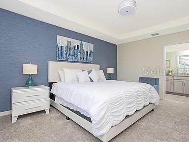 A bedroom features a blue accent wall, a white bed, and a white nightstand — 2182 FLEMING MIST PLACE, KISSIMMEE, FL