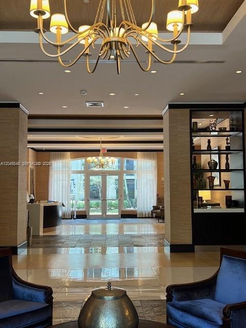 A lobby features a large chandelier, blue armchairs, and a display shelf with decor — 510 NW 84th Ave # 534, Plantation FL 33324, PLANTATION, FL