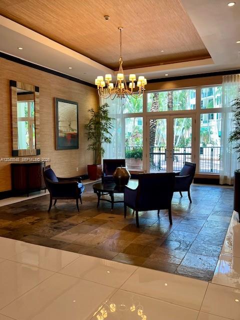 A lobby features a chandelier, dark armchairs, a round table, and large windows overlooking greenery — 510 NW 84th Ave # 534, Plantation FL 33324, PLANTATION, FL
