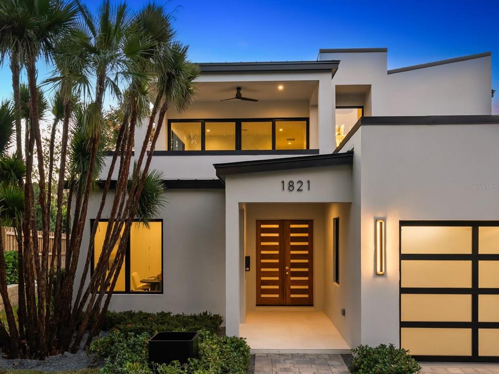 A modern two-story house exterior features a wooden double front door and palm trees — 1821 ENGLEWOOD ROAD, WINTER PARK, FL