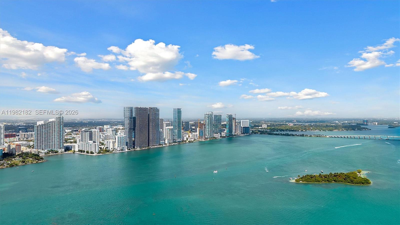 An aerial view shows a coastal city skyline across a large body of water — 700 NE 24rd St # 5802, Miami FL 33137, MIAMI, FL