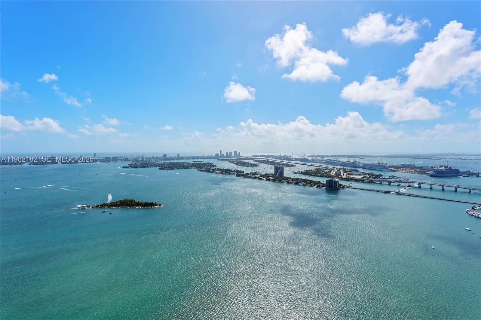 An aerial view shows a body of water with islands, bridges, and a distant city skyline — 700 NE 24rd St # 5802, Miami FL 33137, MIAMI, FL
