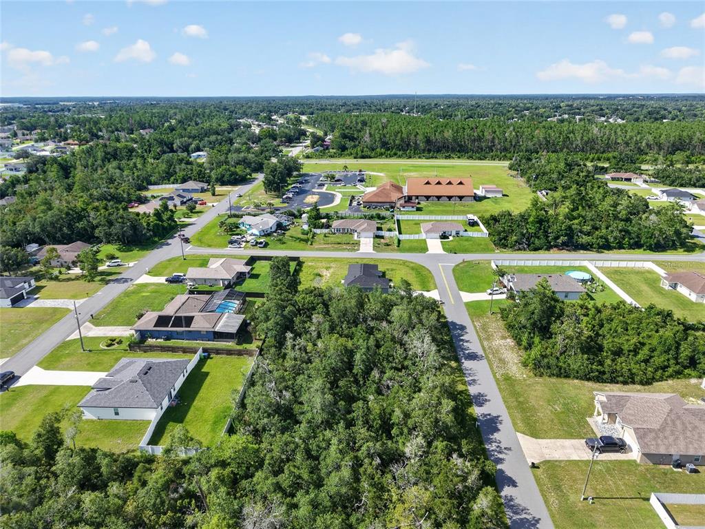 An aerial view shows a residential neighborhood with houses, a large wooded lot, and trees — 0000 SW 42ND TERRACE, OCALA, FL