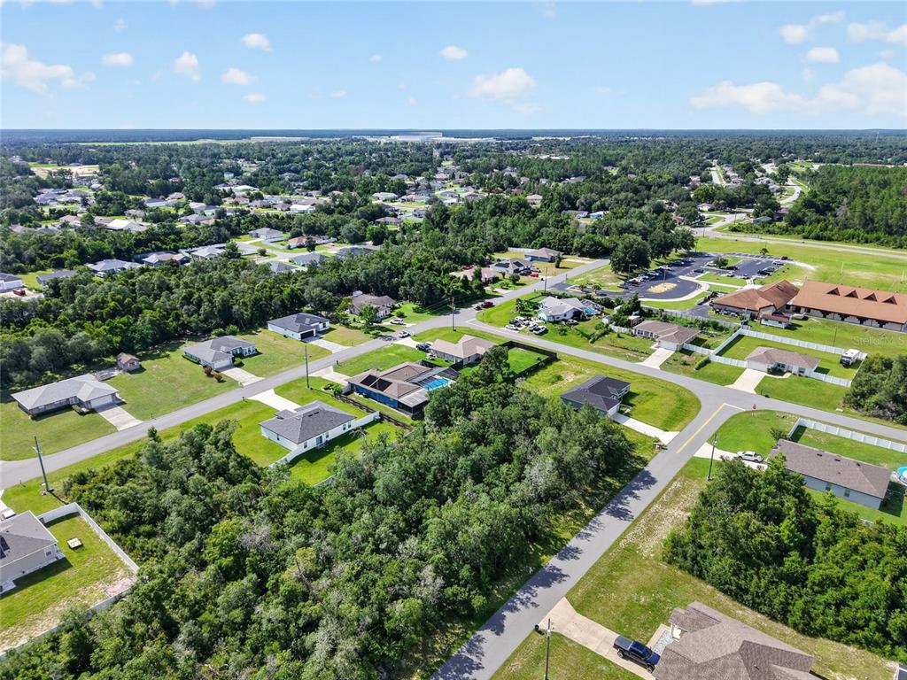 An aerial view shows a residential neighborhood with houses, wooded areas, and paved streets — 0000 SW 42ND TERRACE, OCALA, FL