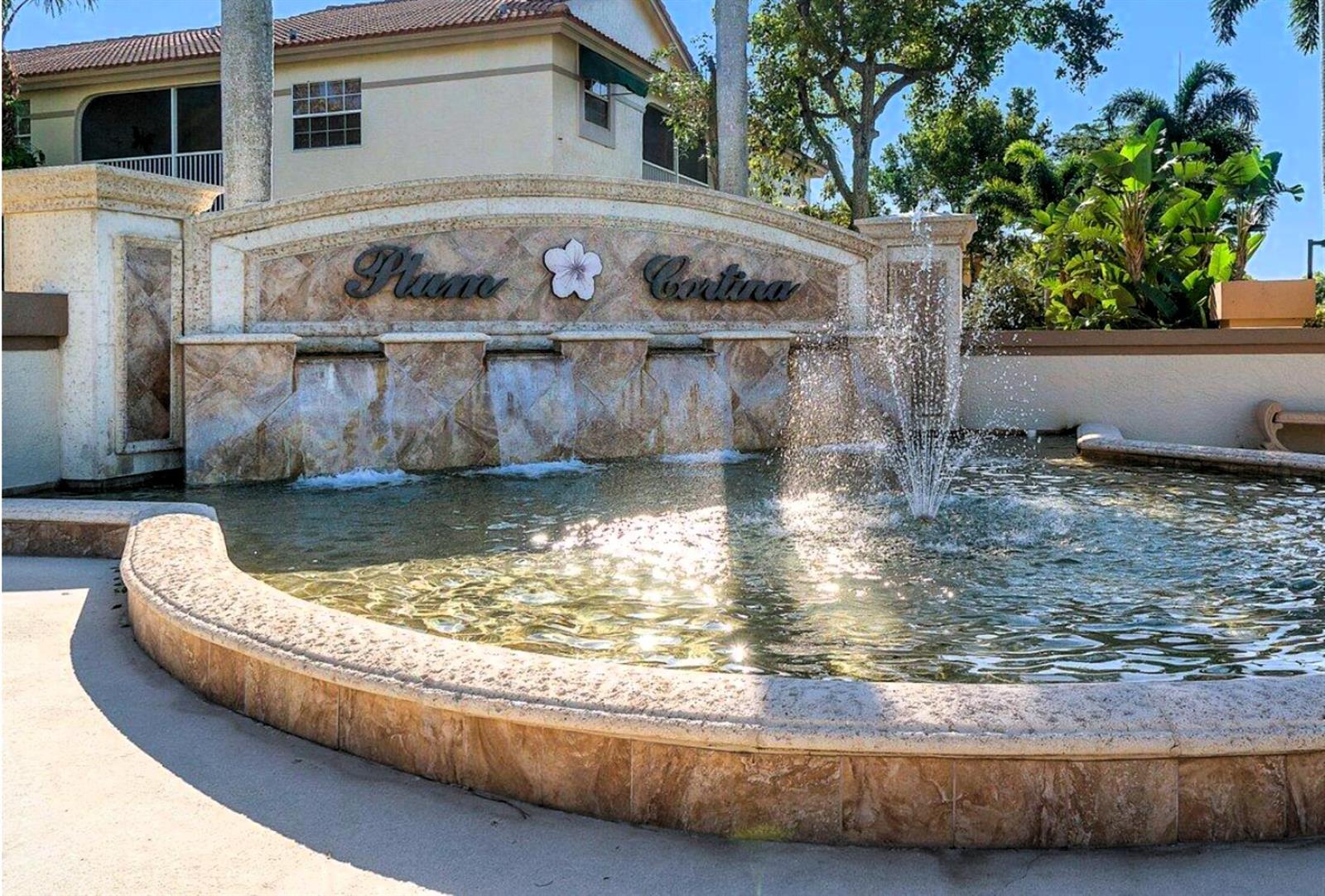 A stone fountain with a tiered waterfall sits in front of a residential community sign — 6757 Via Regina # 3, Boca Raton FL 33433, BOCA RATON, FL