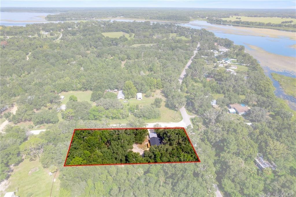 An aerial view shows a house situated on a wooded lot outlined in red — 11437 N YOUNG DRIVE, DUNNELLON, FL