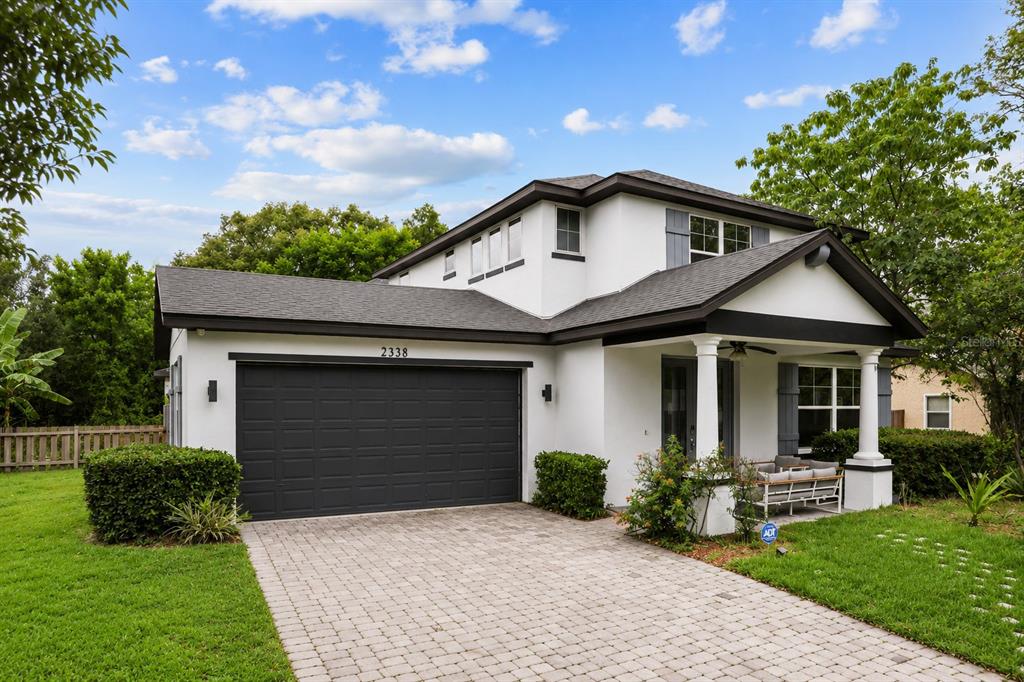 A two-story house with a white exterior, dark trim, and a paved driveway — 2338 S BROWN AVENUE, ORLANDO, FL