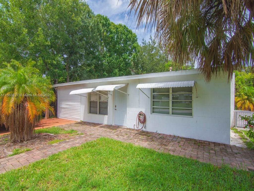 A white, single-story house with a brick walkway and metal window awnings — 1650 5 Ave, Vero Beach FL 32960, VERO BEACH, FL