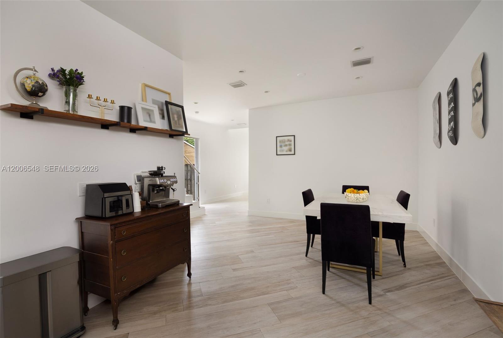 A dining area features a white table, black chairs, a wooden dresser, and wall decor — 2931 SW 27th Ter # 2931, Miami FL 33133, MIAMI, FL