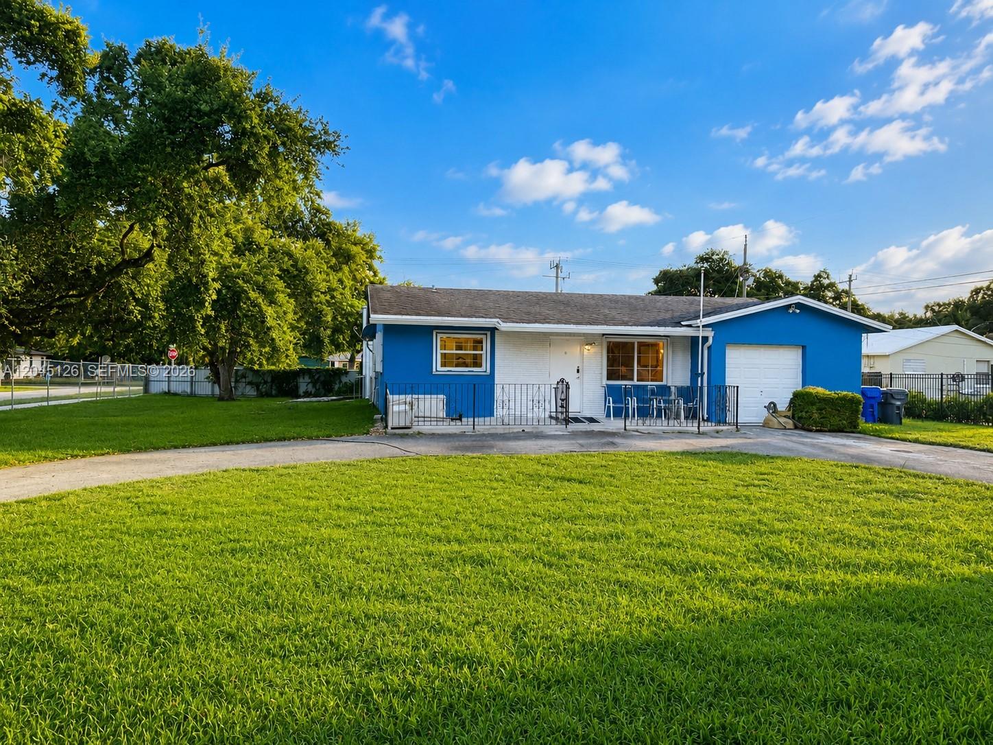 A blue, single-story house with a white garage door and a front lawn — 6145 Hayes St, Hollywood FL 33024, HOLLYWOOD, FL