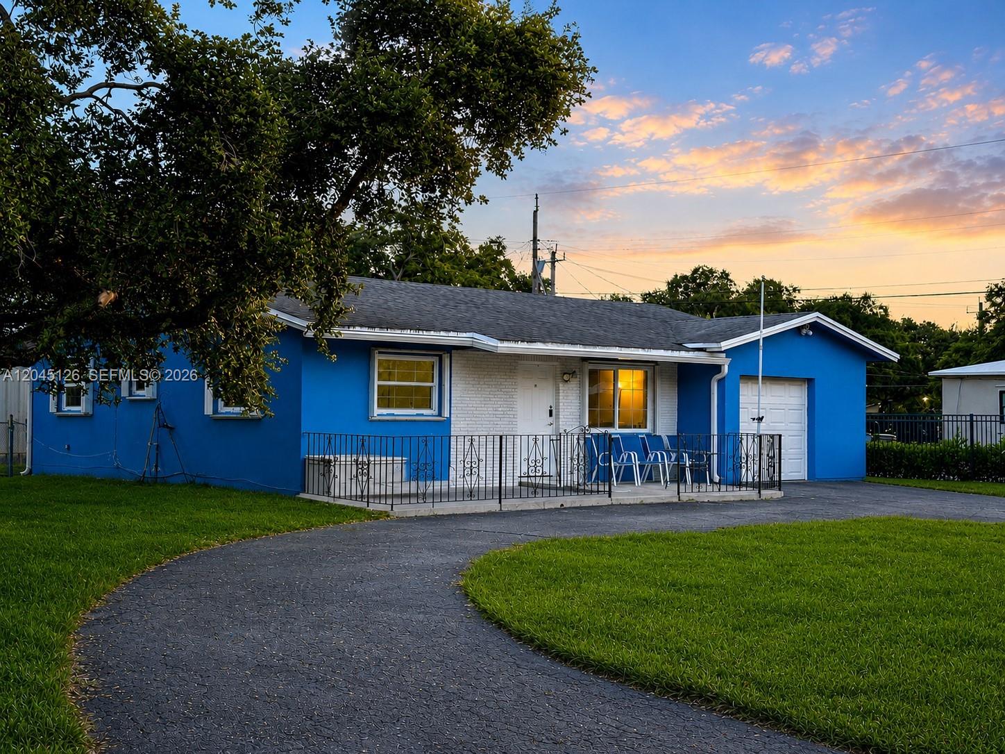 A blue single-story house with a white brick facade and a curved asphalt driveway — 6145 Hayes St, Hollywood FL 33024, HOLLYWOOD, FL