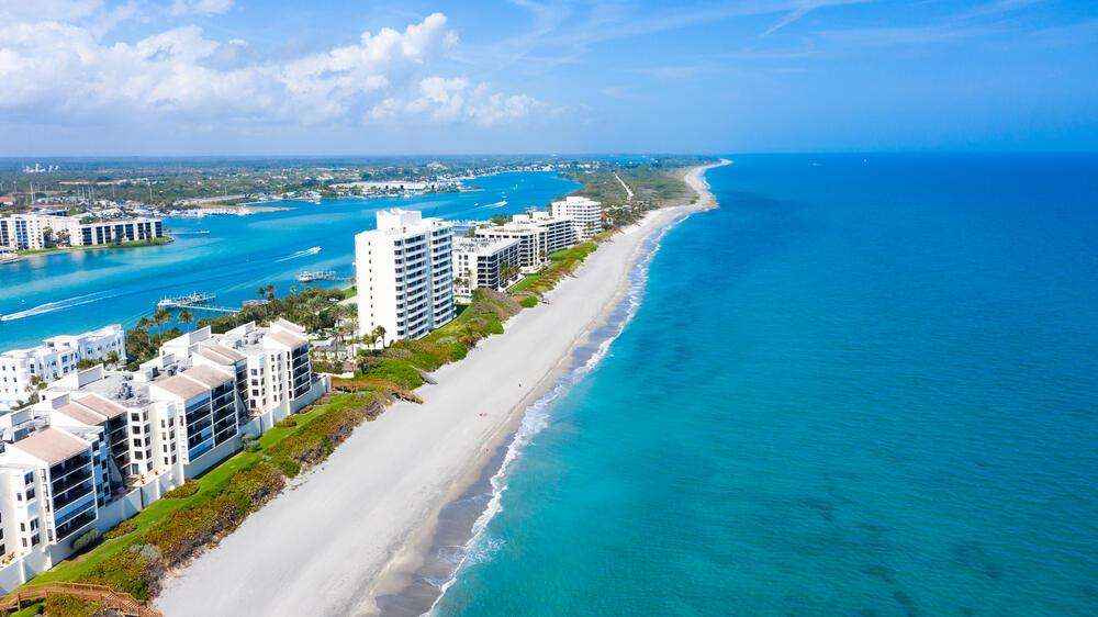 An aerial view of a sandy beach lined with high-rise residential buildings along the ocean — 400 Beach Road # 504, Tequesta FL 33469, TEQUESTA, FL