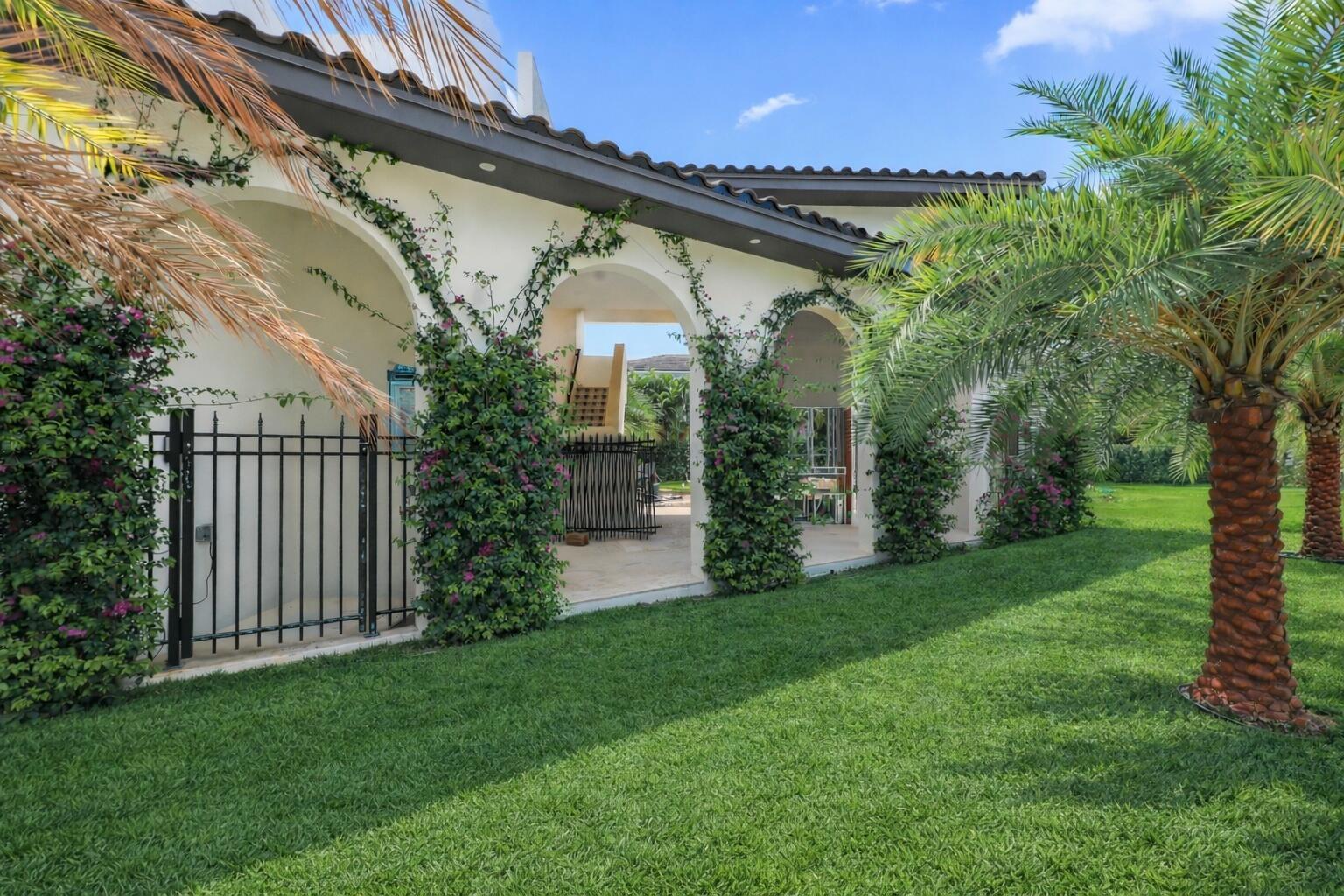 A white house exterior features arched covered walkways, climbing vines, and a manicured lawn — 298 NE 8th Street, Boca Raton FL 33432, BOCA RATON, FL