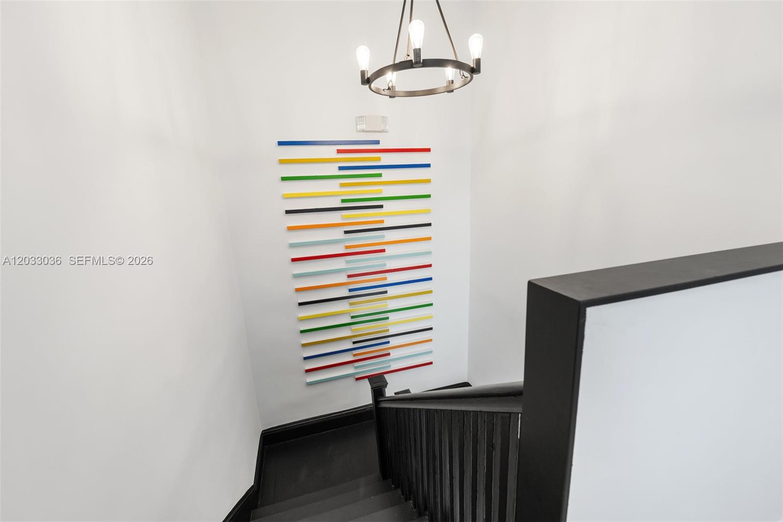 A staircase with black railings and steps features a colorful horizontal wall art installation — 403 SW 12th Ave # 3, Miami FL 33130, MIAMI, FL