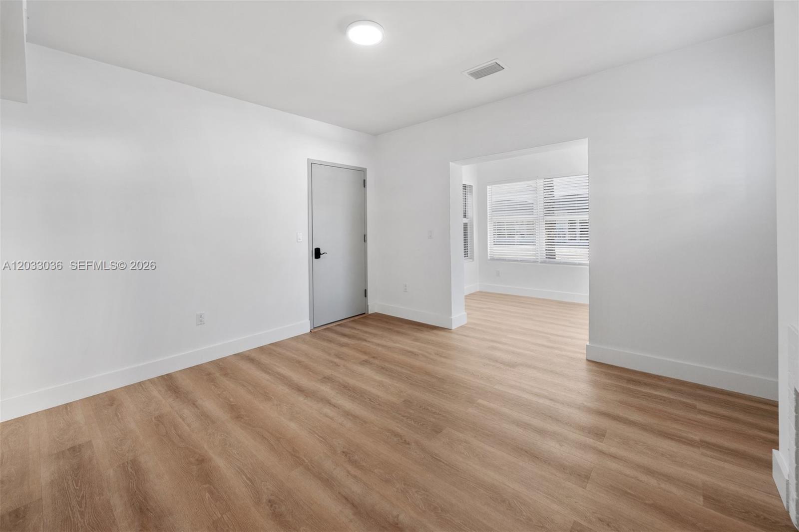 This room features white walls, light wood-look flooring, a gray door, and an adjacent alcove — 403 SW 12th Ave # 3, Miami FL 33130, MIAMI, FL
