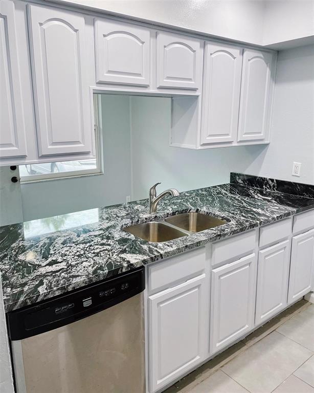 A kitchen features white cabinets, a black and white granite countertop, and a stainless sink — 3767 138TH AVENUE UNIT B, LARGO, FL