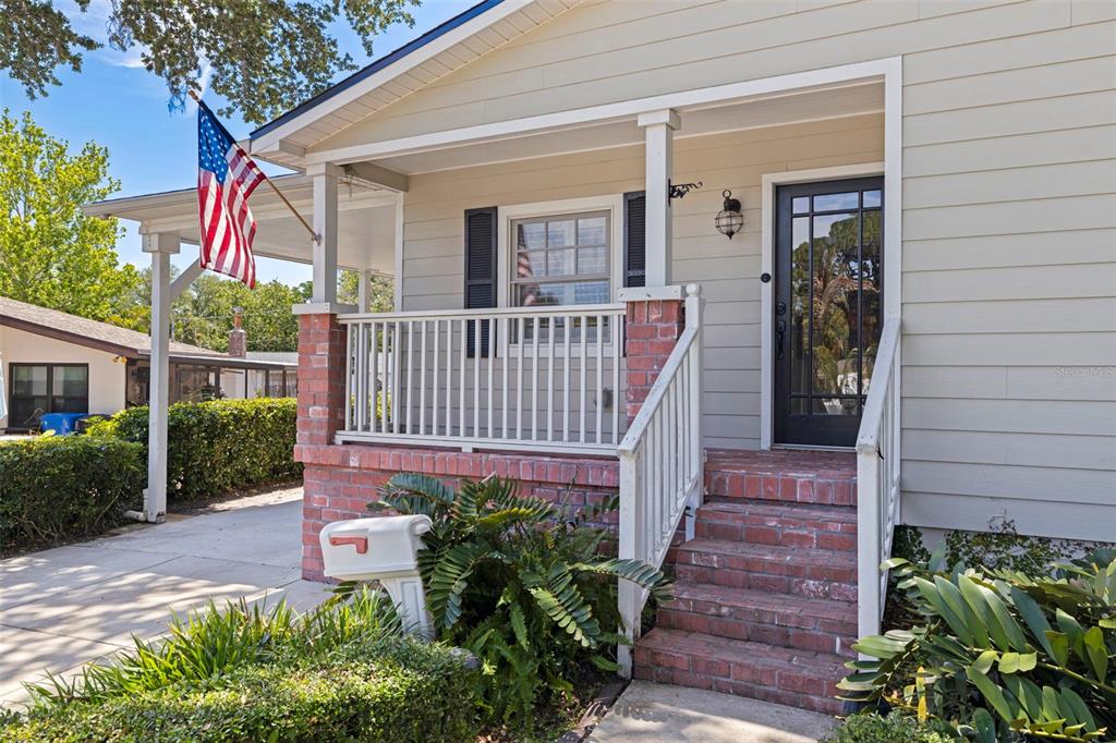 A front porch with brick steps and columns leads to a dark-framed glass front door — 1010 43RD AVENUE N, ST PETERSBURG, FL