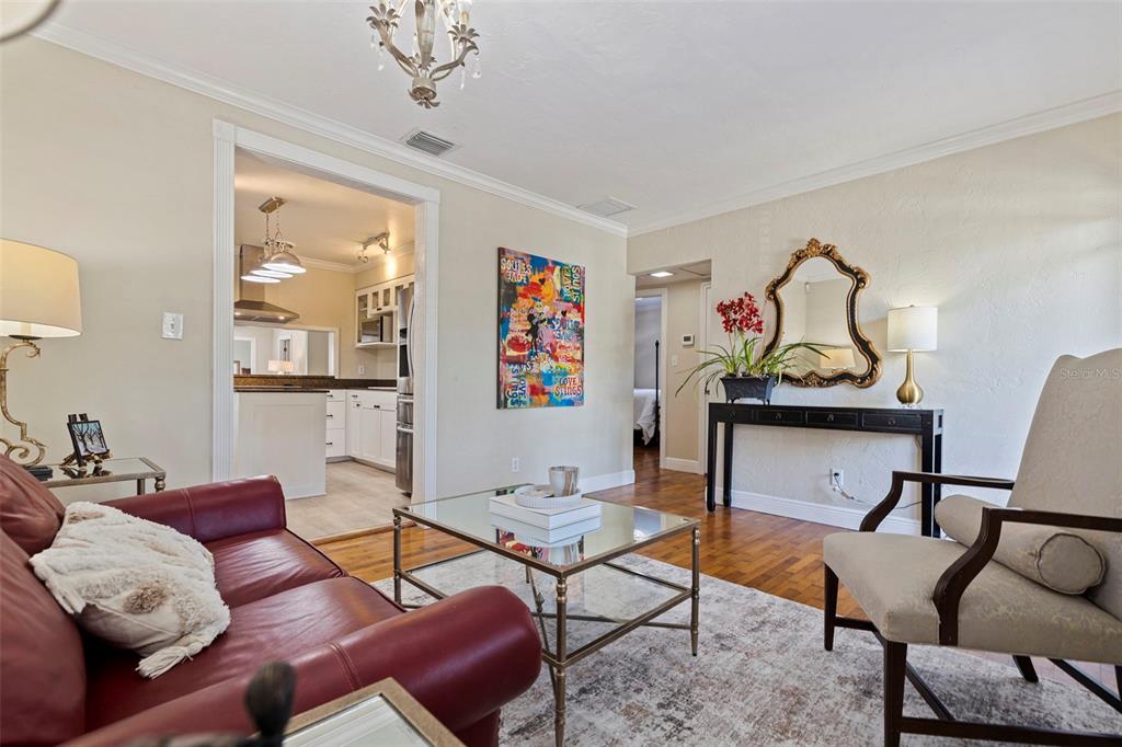 A living room features a red leather sofa, glass coffee table, and an ornate wall mirror — 1010 43RD AVENUE N, ST PETERSBURG, FL